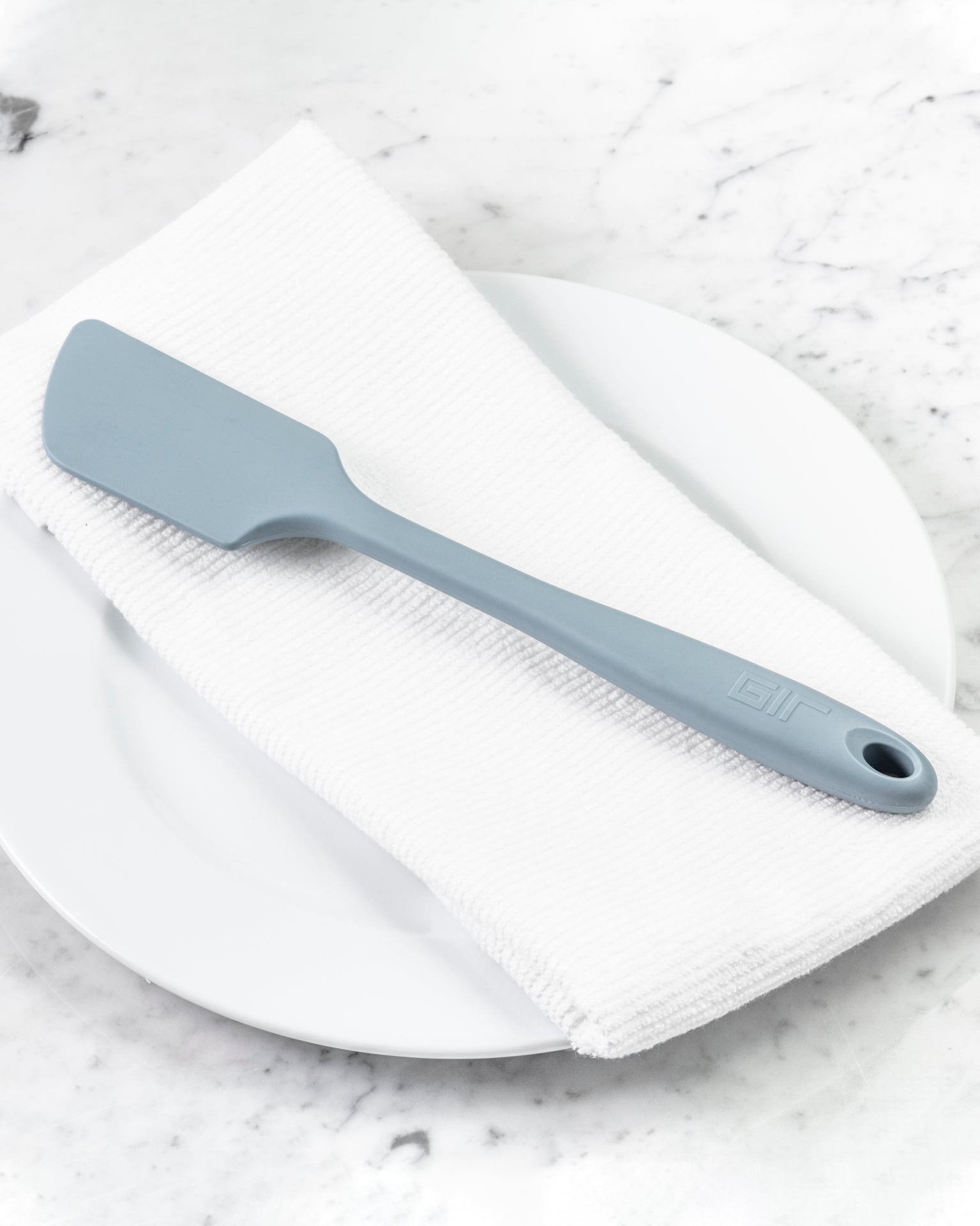 The Slate Ultimate Spatula on a white towel and plate. 